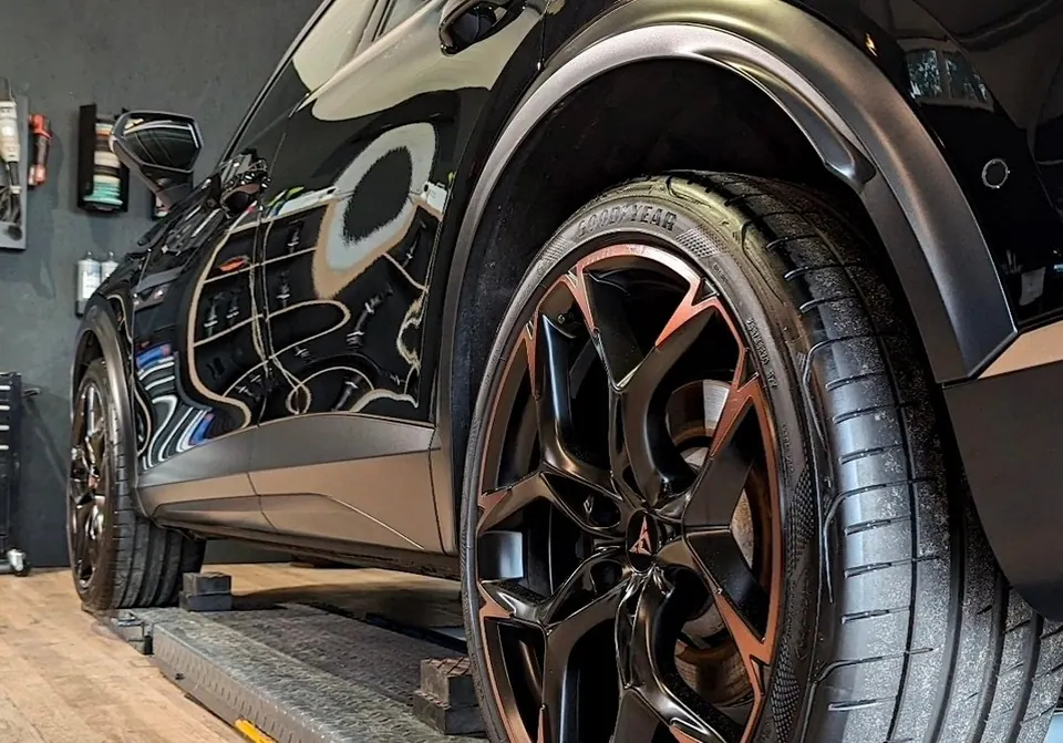 Schwarzer Ferrari in moderner Werkstatt mit LED-Beleuchtung